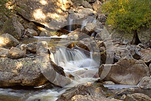 Water fall cascading down a mountain in late afternoon sunlight