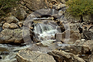 Water fall cascading down a mountain in late afternoon sunlight