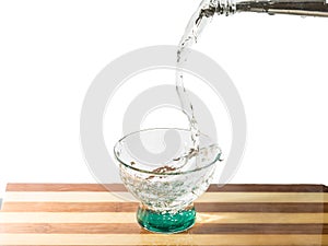 Water falling into glass on cutting board