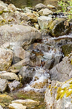 water falling over large rocks and small pebbles