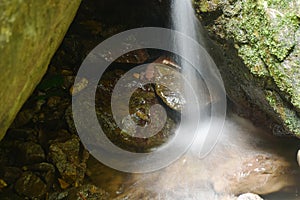 water falling on river pass rock and stone at Pha Gnam Gnon waterfall in Thailand