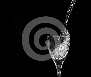 Water falling into a wine glass with a splash