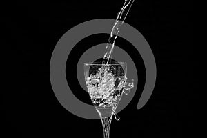 Water falling into a wine glass with a splash