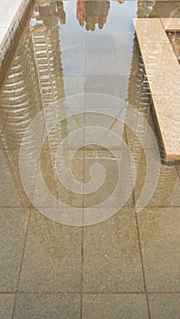 Water feature with Towers and tourists reflected in it