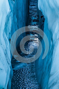 Water filled crevasse reflecting the sky from deep within the Matanuska Glacier