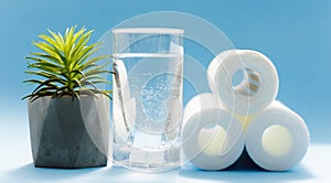 Water filters. Carbon cartridges and a glasses on a blue background. Household filtration system