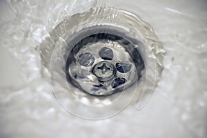 Water flow into drain in white bath
