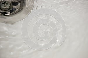 Water flow into drain in white bath