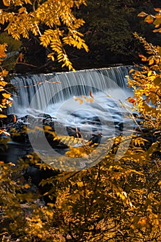 Water flowing down a small picturesque waterfall framed by fall foliage. Madam Brett Park - Beacon, NY