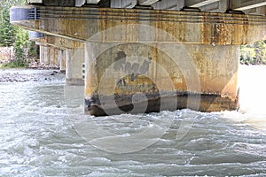 Water flowing fast under a concrete bridge