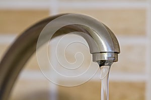 Water flowing from the faucet in the kitchen