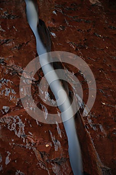 Water flowing through fissure in red rock, Zion National Park, Utah