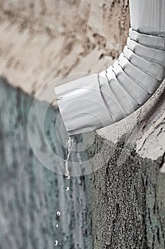 Water flowing out the end of an eavestrough photo