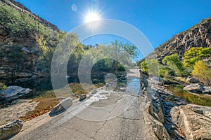 Water flowing over the bridge in the middle of rocky desert mountains at Sabino Canyon State Park