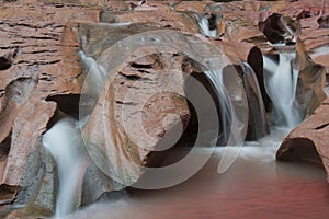 Water flowing over red rock