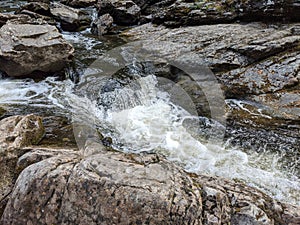 Water flowing over rocks in mountain forest