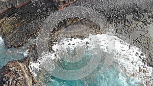 Water flowing over rocks and shingle beach on the Atlantic ocean.