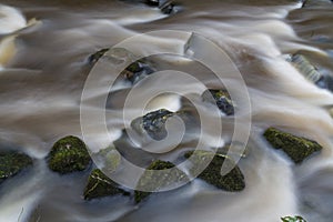 Water flowing over stones. near base of waterfall winter.