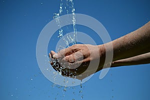 Water flowing from the sky into open hands