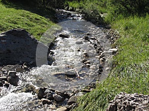 Water flowing and splashing over rocks in a mountain river stream