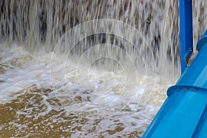 Water flowing in a stream from the threshold of a dam in a small hydroelectric power plant.