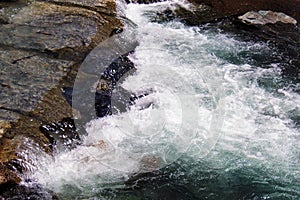 Water flowing white with foam in a mountain creek