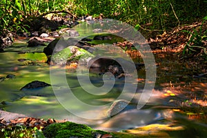 The water flows from the creek flowing through the rocks in the tropical Rainforest in Thailand,Phang Nga,Koh Yao Yai