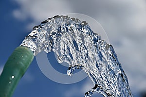 Water flows from the garden hose. Wasteful wasting water. Global warming shortage of water.