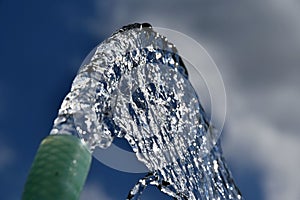 Water flows from the garden hose. Wasteful wasting water. Global warming shortage of water.