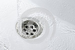 Water flows into a new white sink in the bathroom