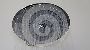 Water flows out of the big round shower head. Water stream.