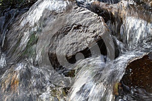 The water flows quickly between the dark stones