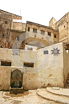 Water fountain, houses and street signs in the ancient medina of