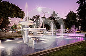 Water fountain illuminated whith colored lights at night.