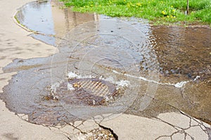 Water fountain pours out from sewer hatch, breakthrough sewerage system, accident of water supply