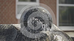 A water fountain with a spinning ball. a statue of a ball in a fountain.