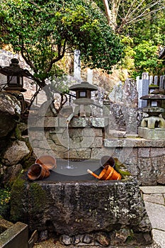 Water fountain with wooden buckets by the staircase of the entrance of Nigatsudo temple, part of Todai-Ji in Nara, Japan