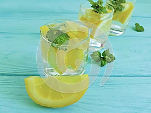 water fresh lemon, mint blue wooden background summer drink