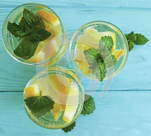 Water fresh lemon, mint refreshing lemonade homemade blue wooden background summer drink