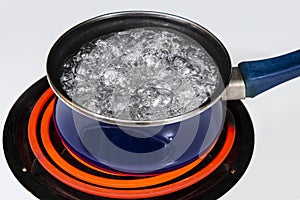 Water In Full Rolling Boil Inside Blue Pan On Stove Top