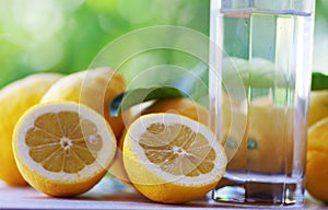 water glass and yellow lemons