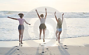 Into the water we go. three friends spending the day at the beach.