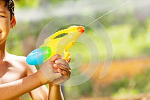 Water gun close up in hands of a little boy