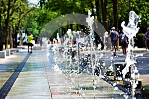 Water gushing from the fountain in the middle of the sidewalk