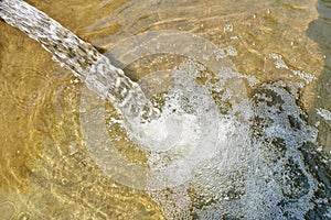 Water gushing out of the pipe close up