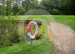 Water hazard with life buoy on golf course.