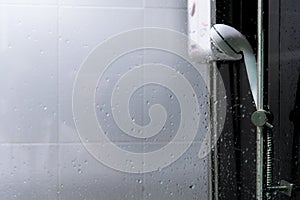 Water heater and shower spray in bathroom.