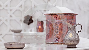 Water jar and copper bowl with soap foam in turkish hamam. Traditional interior details