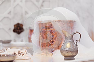 Water jar, towel and copper bowl with soap foam in turkish hamam. Traditional interior details