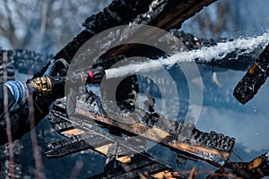 Water jet splashing from a fire fighting firehose nozzle. Firefighter spraying high pressure water to fire. Strong